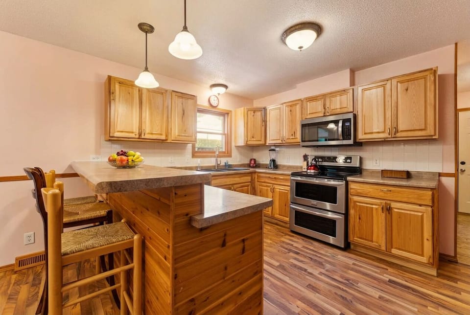 Bright kitchen with island seating, ample counters, and warm wood finishes