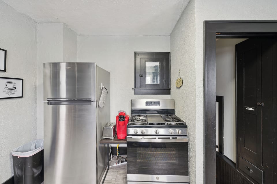 Coffee-making supplies, full-size refrigerator, and cooking stove.