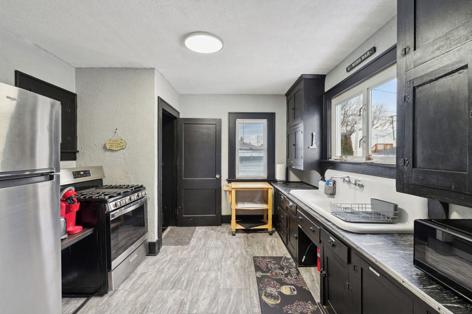 Fully stocked kitchen including dishes and cookware.