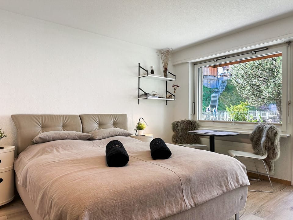 View of the large double bed with window that lights up the room.