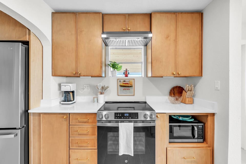 Stainless steel stove and oven with cabinet space.