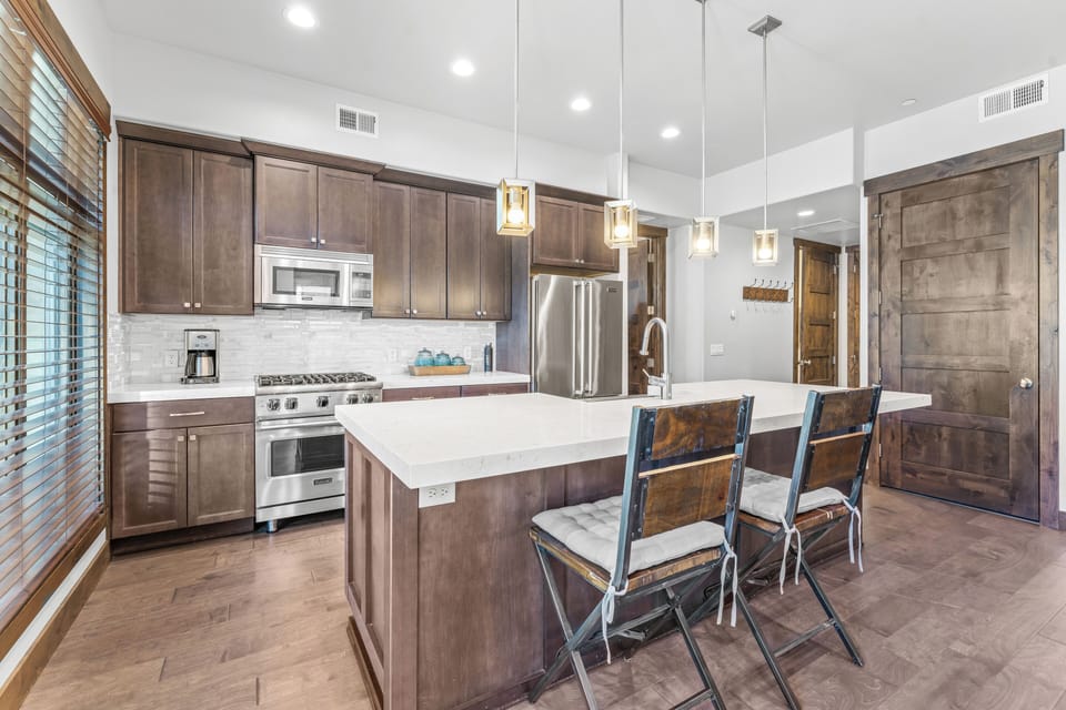 - Gourmet kitchen with stainless appliances and island seating  
- Stylish pendant lighting adds elegance to the open design  
- Fully equipped space perfect for cooking and entertaining