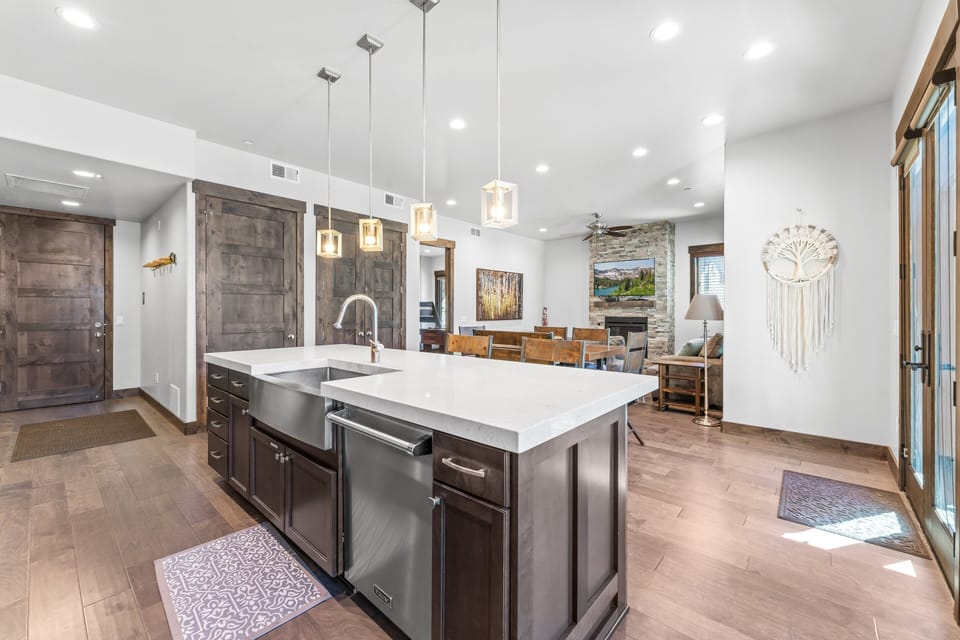 - Spacious kitchen with waterfall island and stainless steel appliances  
- Pendant lighting creates an inviting glow above the breakfast bar seating  
- Open concept flows seamlessly into dining and living areas with fireplace