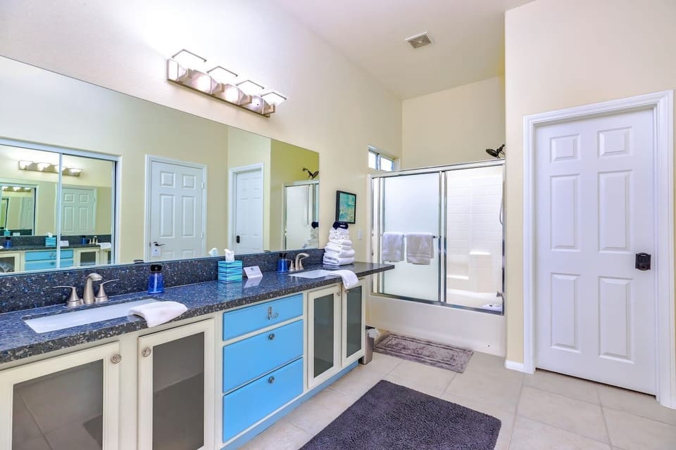 Guest bathroom with double vanity sink and a shower/tub combination. 
