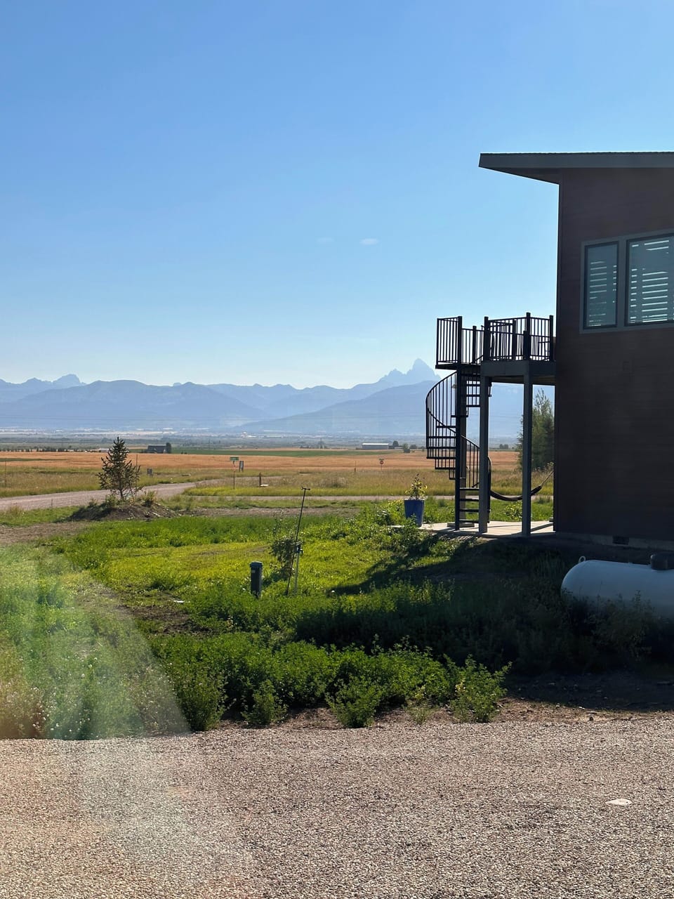 The bedroom features a queen bed, a spacious closet, and a peek of the Tetons.