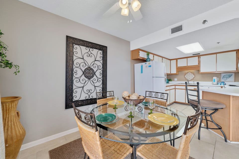 Gather around this elegant glass-top dining table with seating for four. Located adjacent to the kitchen, this comfortable space is perfect for family meals, board games, or morning coffee before hitting the beach.