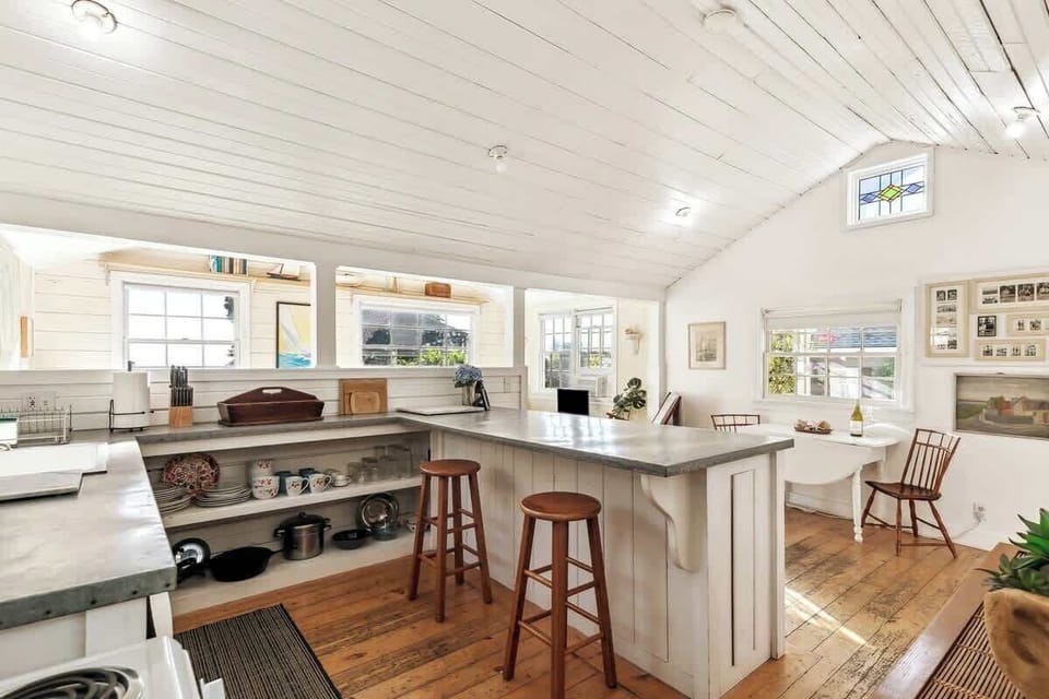 Airy kitchen layout with island seating and rustic wood floors—ideal for casual dining, morning coffee, and easy conversations.