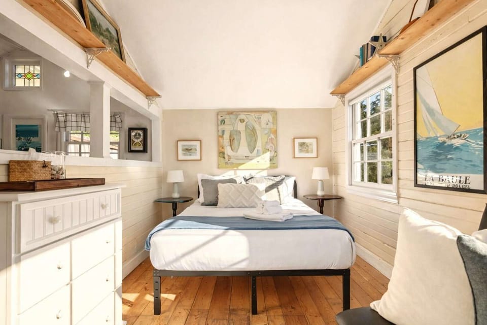 Bright and cozy bedroom with warm wood floors, soft linens, and natural light for a relaxing stay.