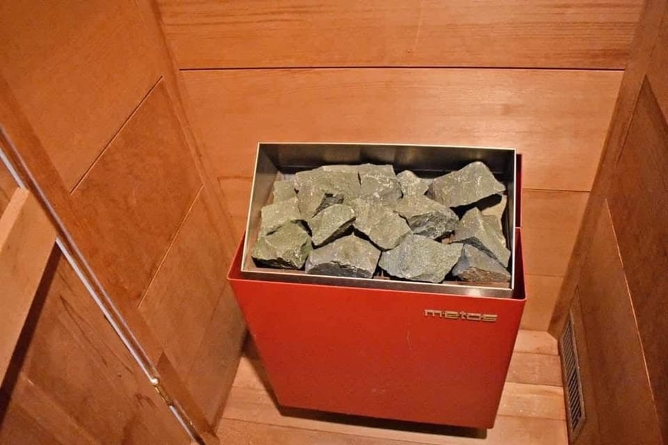 Private sauna heater with traditional sauna stones, ready to create a warm and relaxing spa-like experience.
