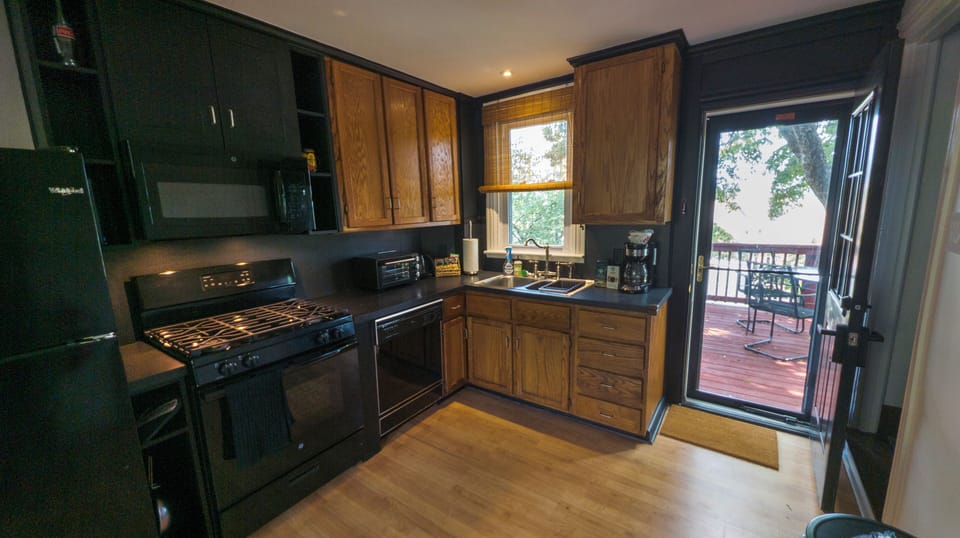 Full kitchen opens out to deck with outdoor seating.