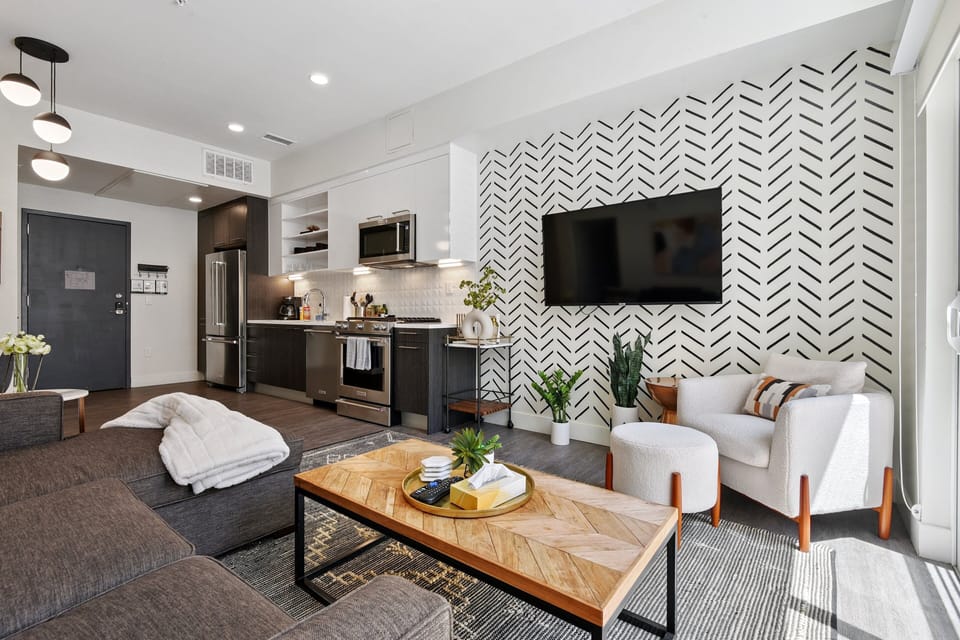 Floor-to-ceiling windows flood the open living space with natural light at EcoLoft Retreat in Espadin LoHi.