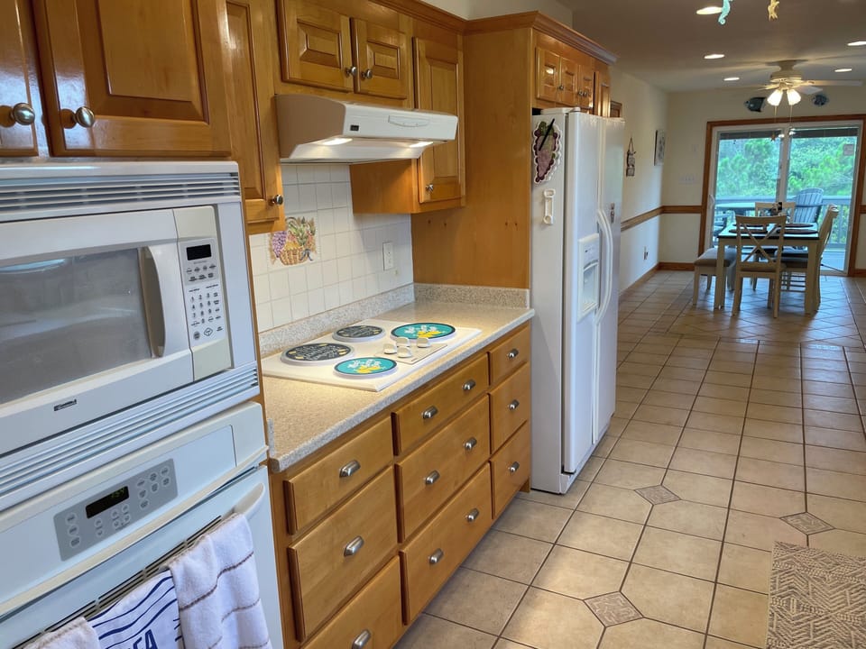 A full kitchen that is fully stocked with pots, pans, plates, and more!
