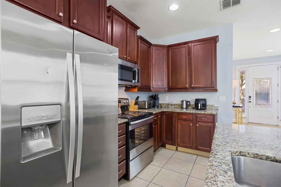 Modern kitchen with stainless steel appliances and granite countertops.