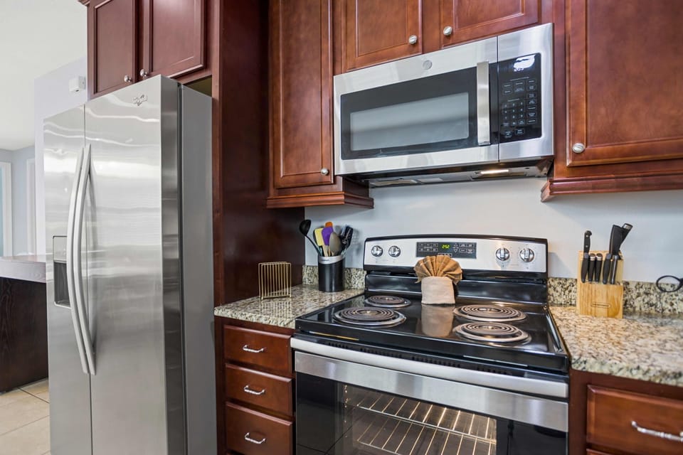Modern kitchen with stainless steel appliances and granite countertops.