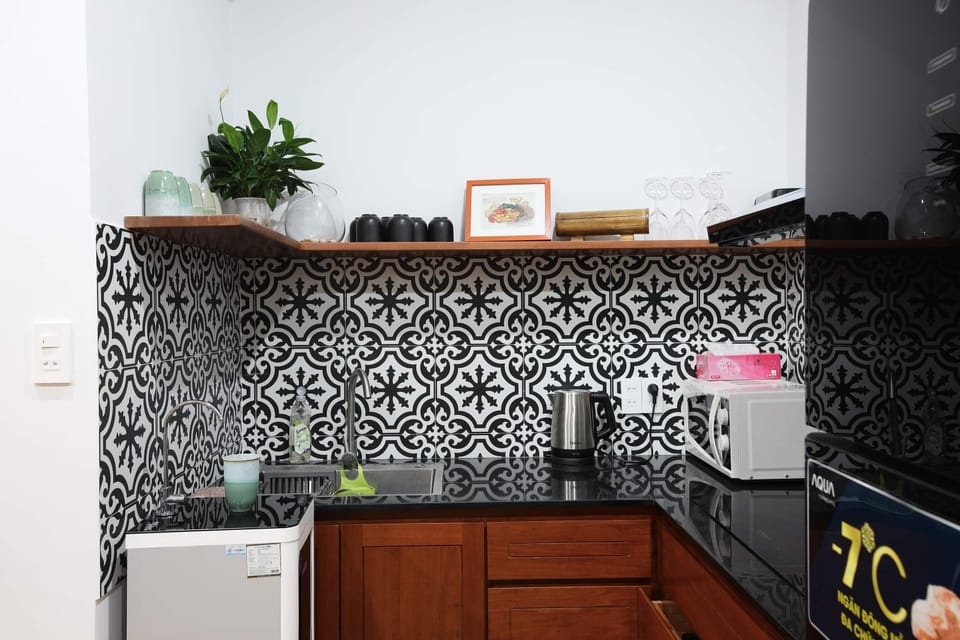 Equipped kitchen with a toaster, a microwave, a kettle, untensil, pots, plates..
