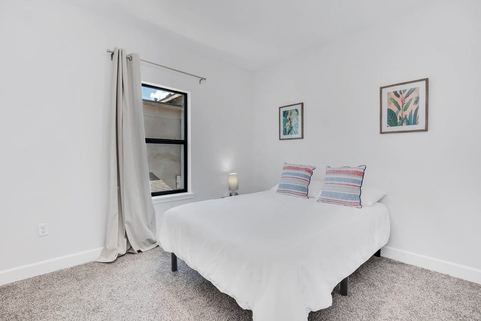 Another bedroom with plush bed and modern simplistic decor. 