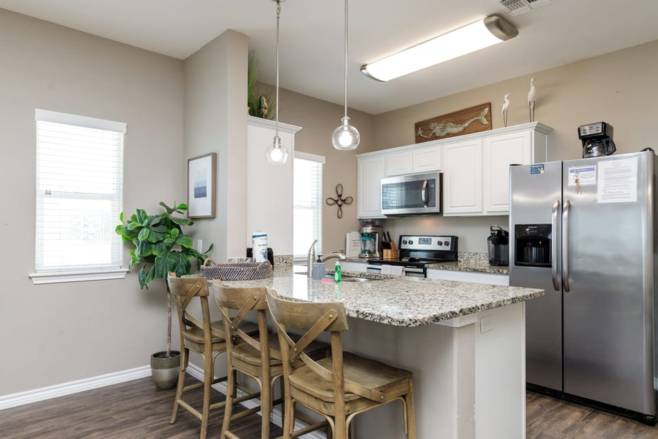 Your fully equipped kitchen features granite countertops, stainless steel appliances, and a breakfast bar perfect for morning coffee or casual meals.