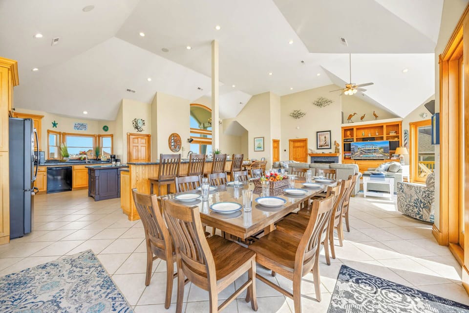 Imagine your whole group gathered around this stunning table, sharing stories and laughter under soaring ceilings. The spacious open layout connects your dining moments with a fully-equipped kitchen and inviting living area—perfect for making memories toge