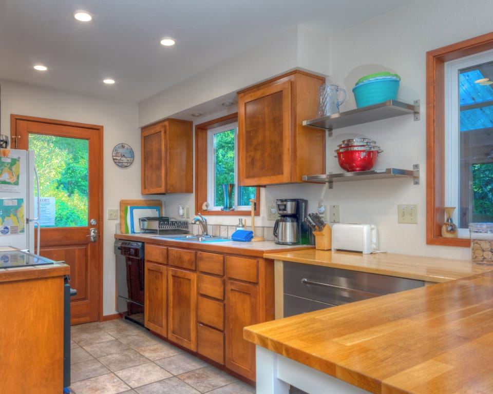 Fully equipped kitchen with access out to back deck with hot tub and outdoor dining area.