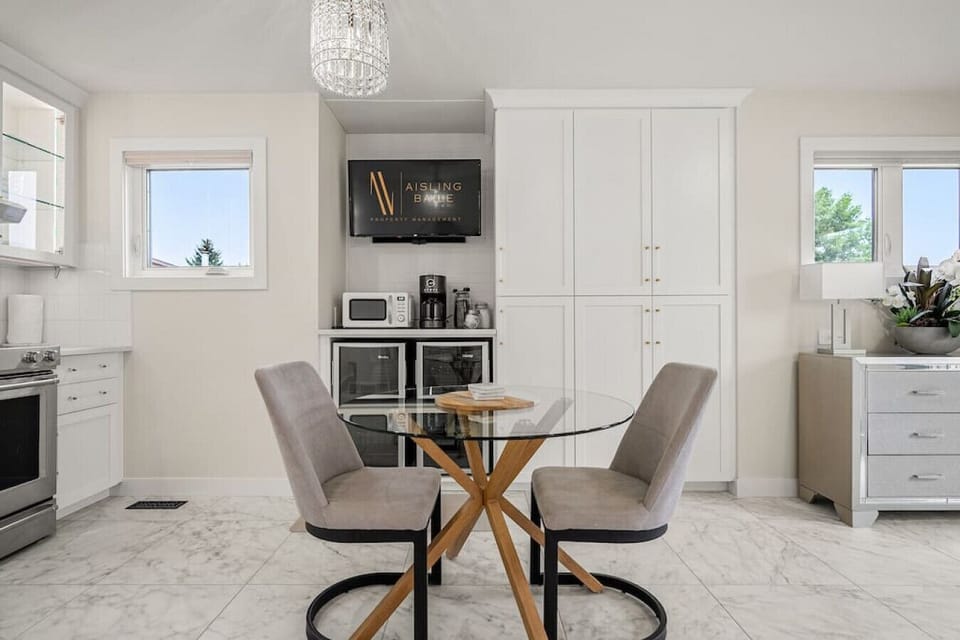 Kitchen area on the main floor with a mini fridge, smart TV, dining area, stove/oven, drip coffee maker, ground coffee, tea, sugar and basic condiments (ketchup, mustard and relish.)