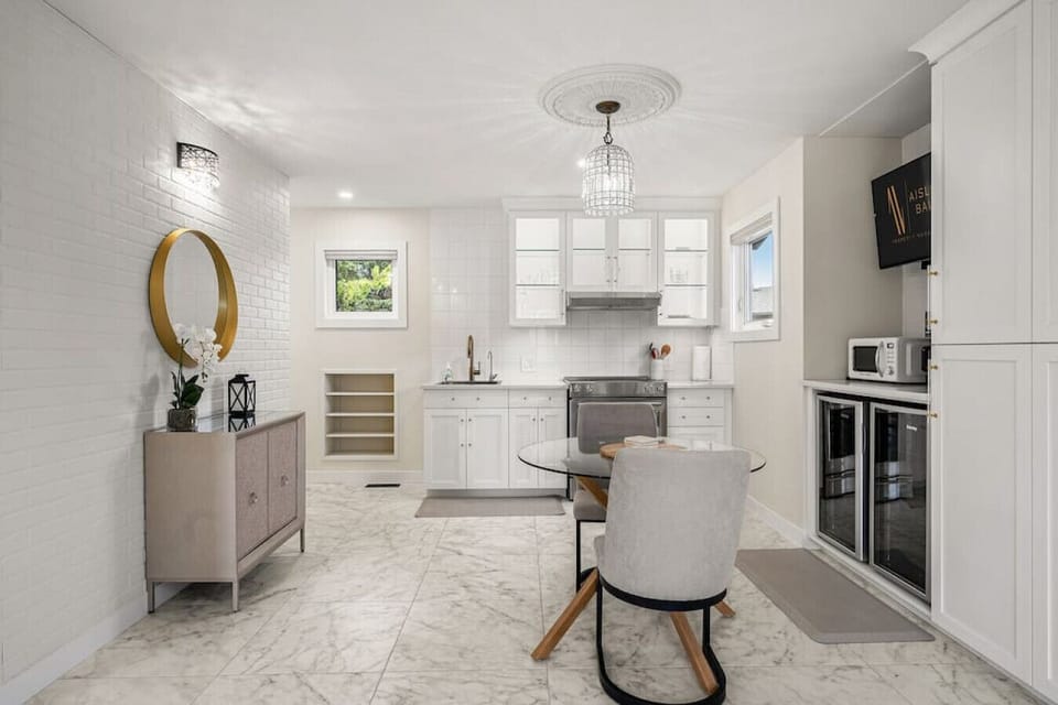 Kitchen area on the main floor with a mini fridge, smart TV, dining area, stove/oven, drip coffee maker, ground coffee, tea, sugar and basic condiments (ketchup, mustard and relish.)