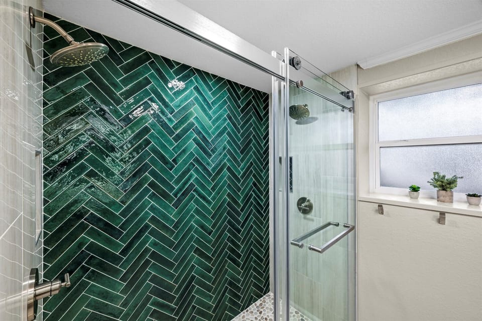 Stunning green tile shower adds a splash of modern style to this charming cabin.