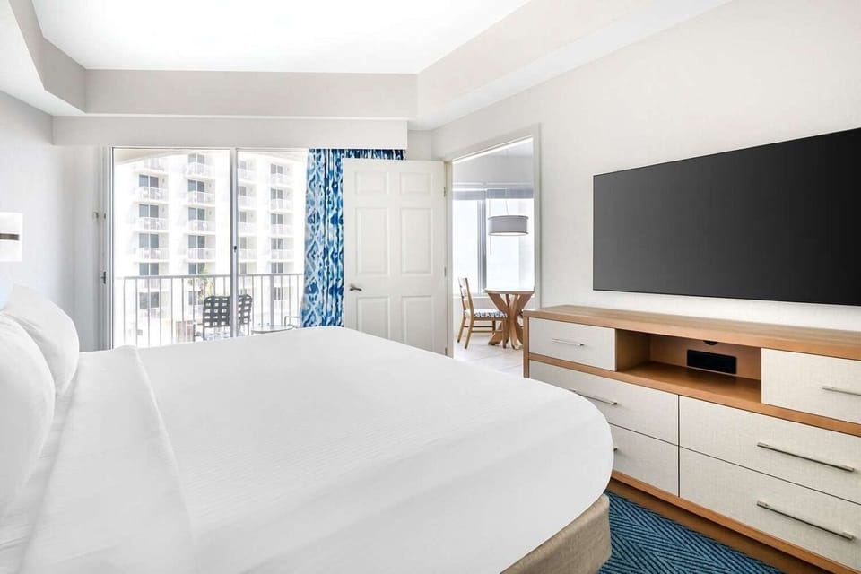 Primary Bedroom • Queen Bed, Blue Accents & Balcony Access