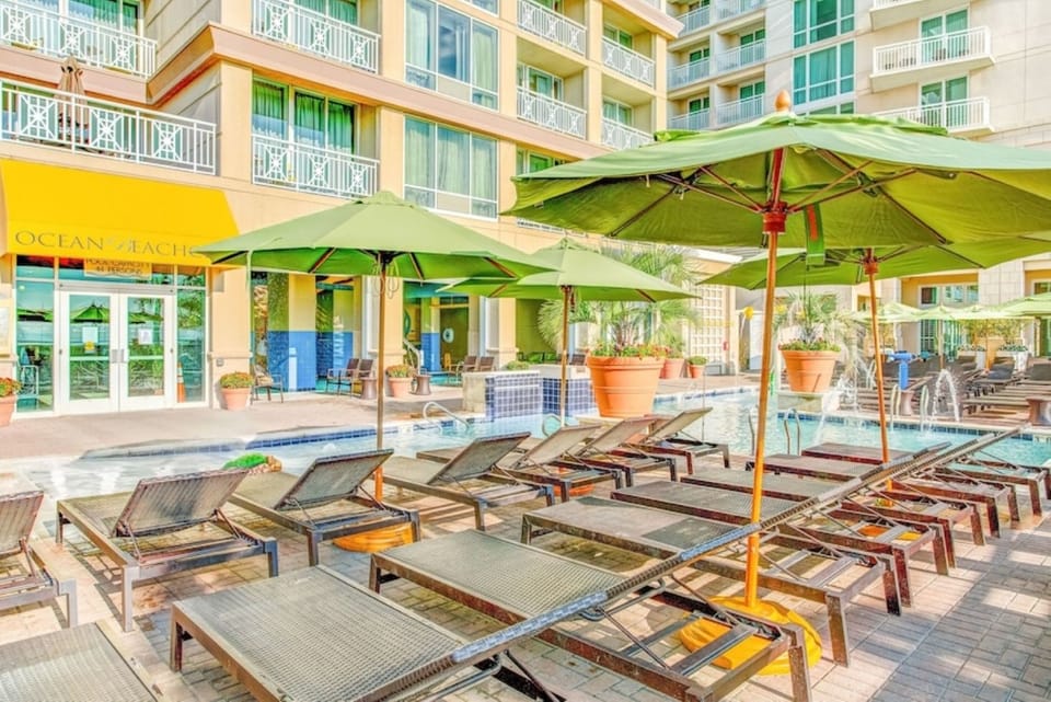 Pool Deck • Lounge Chairs, Green Umbrellas & Lobby Entrance