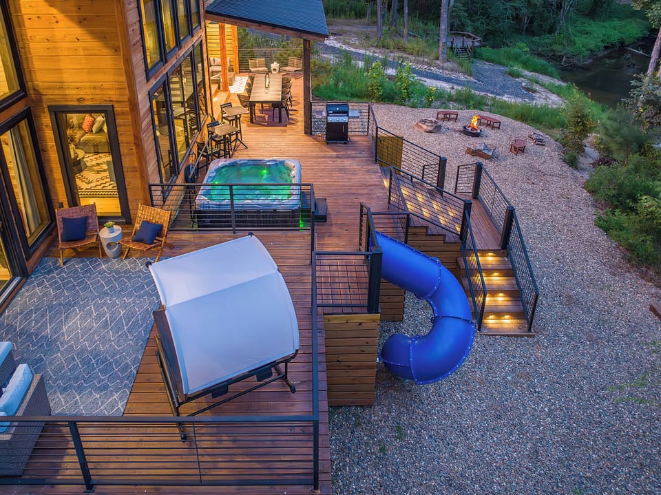 Back deck looking from the main bedroom to the hot tub and covered deck and table/chairs with seating for 8.