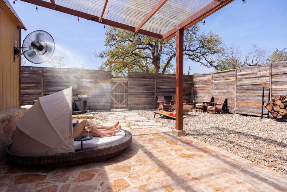 Shaded daybed with canopy and misting fans. The recovery step between the plunge pool and the fire pit.
