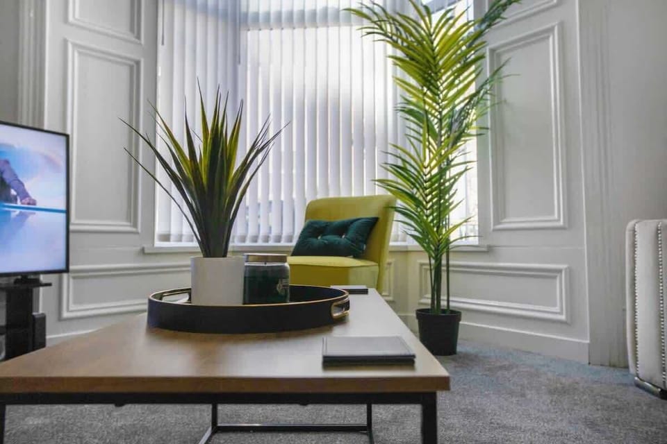 The open and inviting lounge includes a Smart TV, ample seating, and a stylish accent chair, providing a comfortable spot to gather, unwind, or enjoy a peaceful evening.