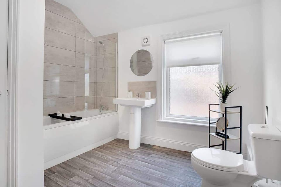 The main bathroom features a full-sized bath with an overhead shower, along with a toilet and wash basin, providing everything you need to freshen up and unwind during your stay.