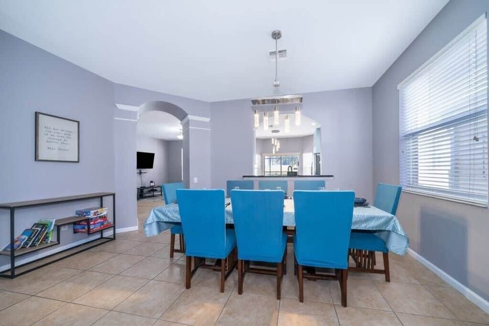 This grand dining area is designed for both style and function, featuring a stunning table with eight plush chairs, perfect for entertaining guests in a luxurious setting.