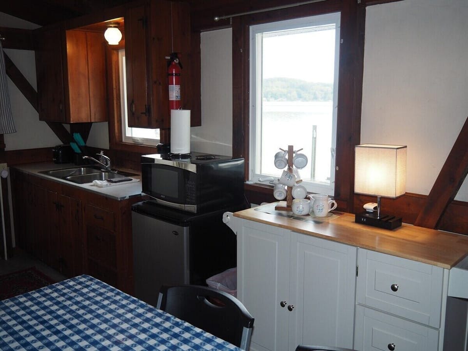 KITCHEN:  The cottage has a small kitchen with all appliances except for a dishwasher.  It does include a separate beverage cooler as well as a good supply of cooking and dining utensils.