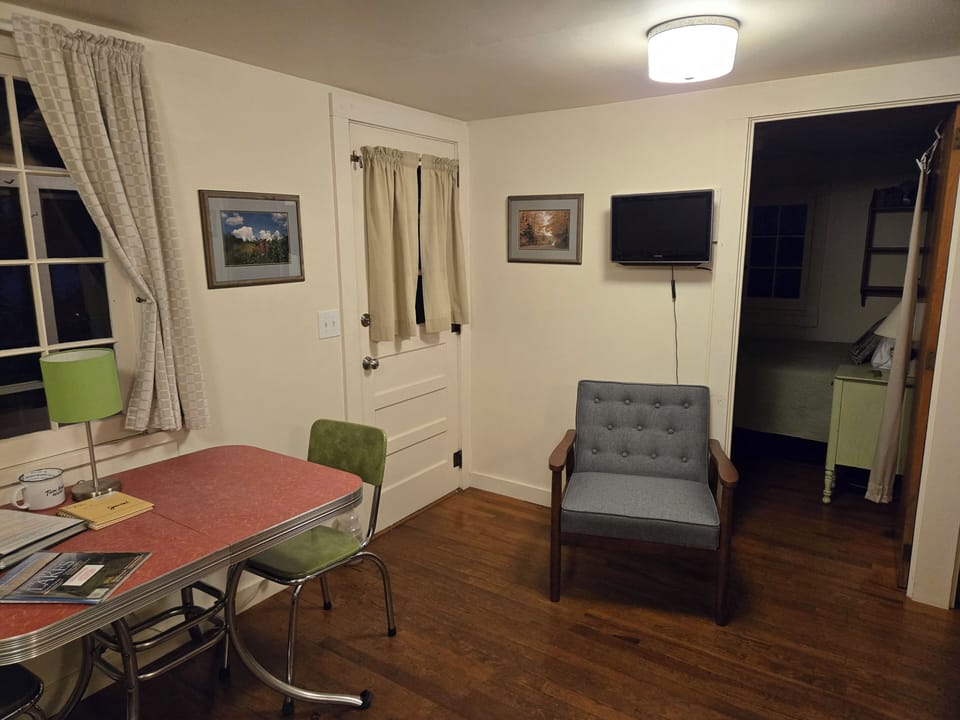 LIVING ROOM:  The cabin has a cute little living room with a loveseat, dining table, and streaming television.