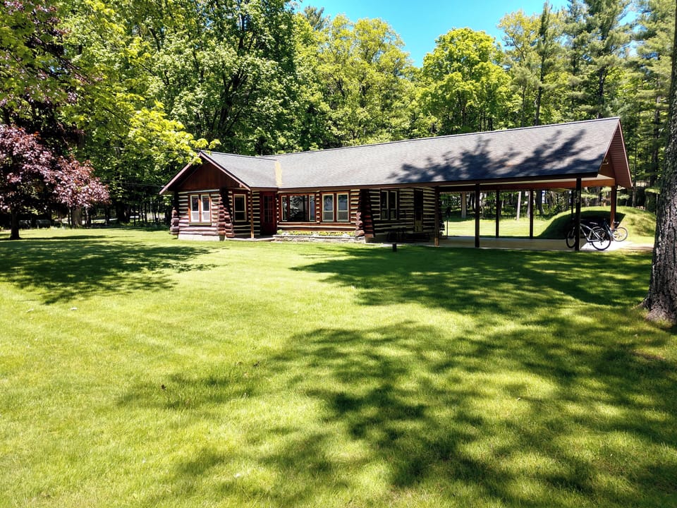 EXTERIOR:  Another view of the front of the cabin in summer.