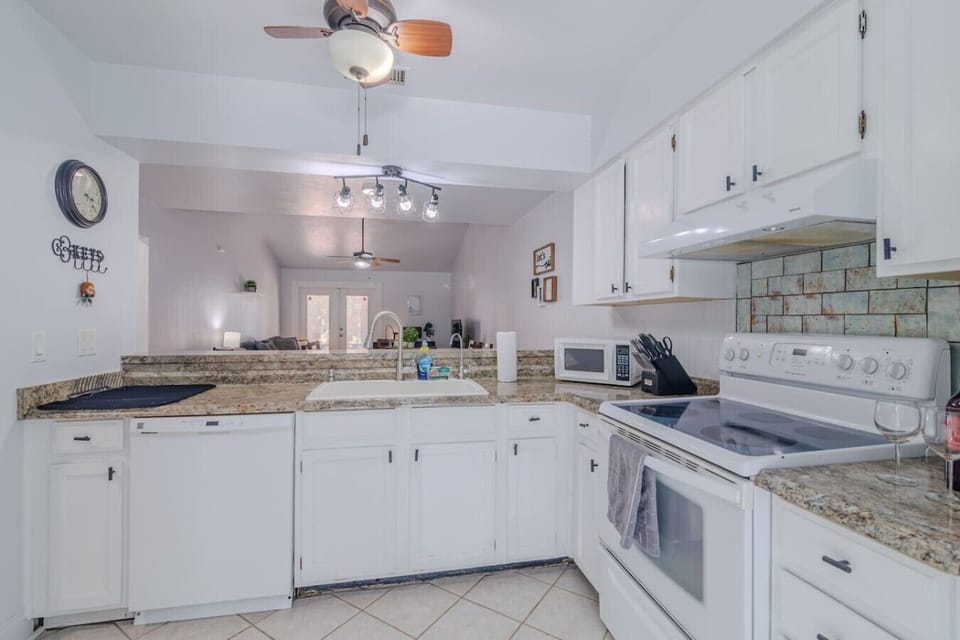 Kitchen overviewing the dining room and living room. Fully stocked with pots, pans, blender, toas