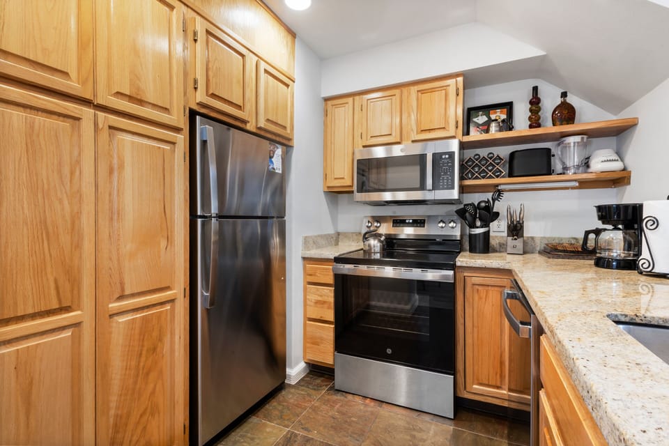 kitchen with stainless steel appliances-electric oven, refrigerator, microwave and dishwasher.