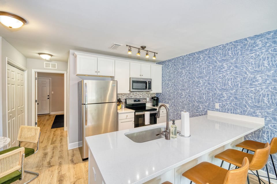 Whole view of the kitchen showcasing island kitchen with bar seating
