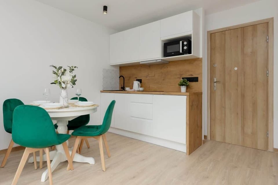 Another perspective of the dining area, showing its connection to the kitchen and wooden accents.
