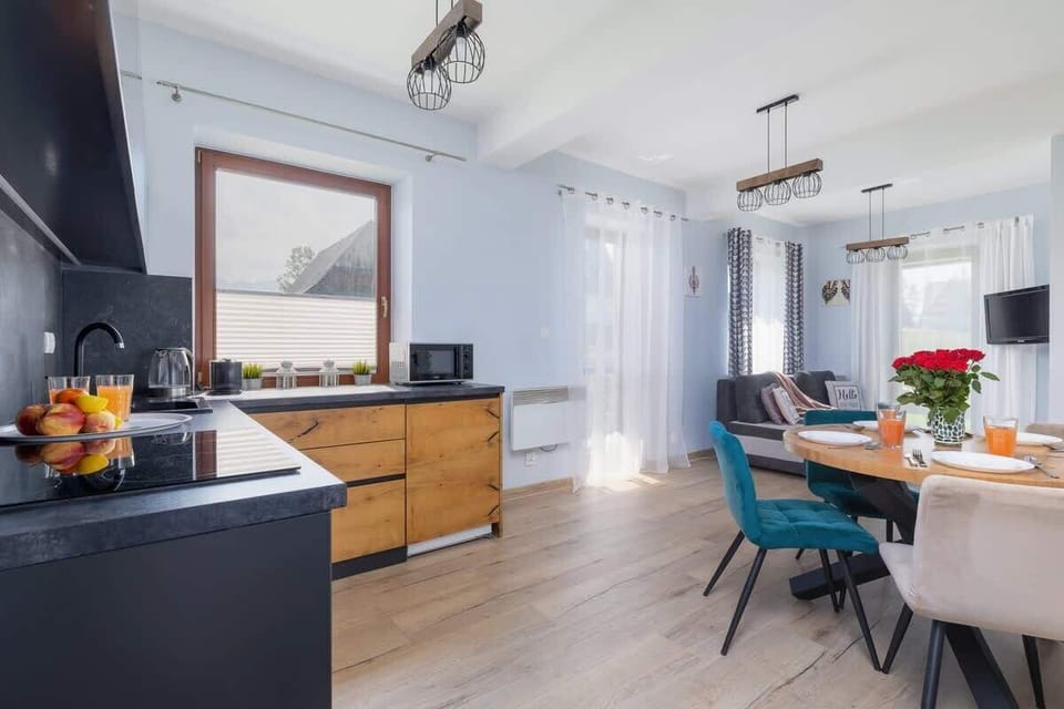 A fully equipped kitchen with sleek black accents, wooden cabinetry, and fresh fruit waiting to be enjoyed.
