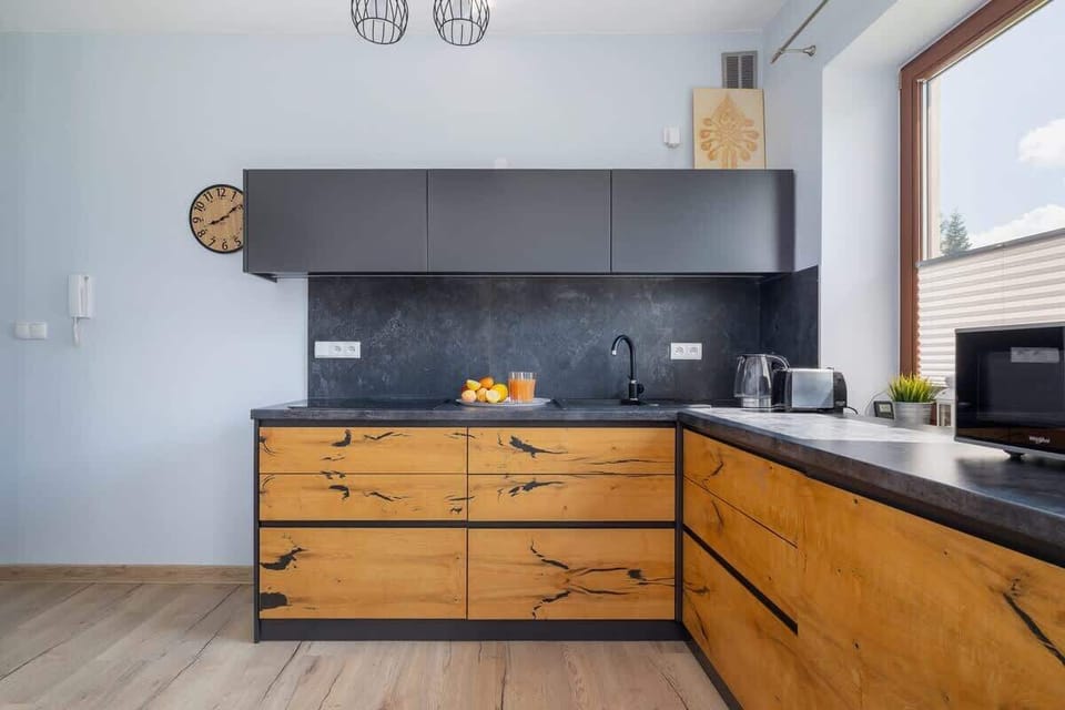 The main kitchen area featuring elegant wooden cabinets, a window for natural light, and all necessary appliances.
