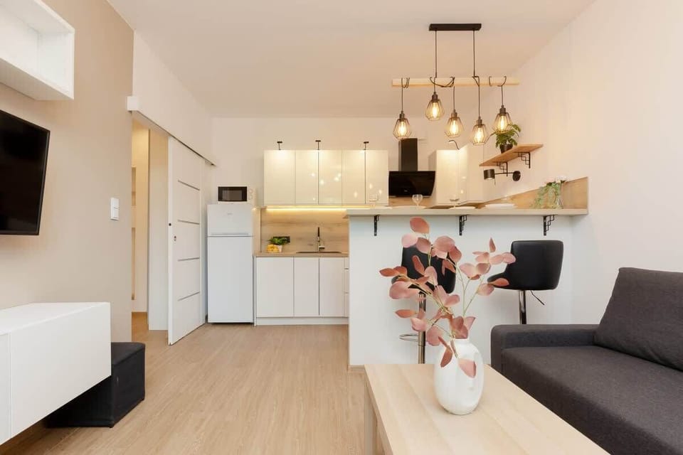 A wide-angle shot of the living and dining area, showcasing the connection between the kitchen and seating space.

