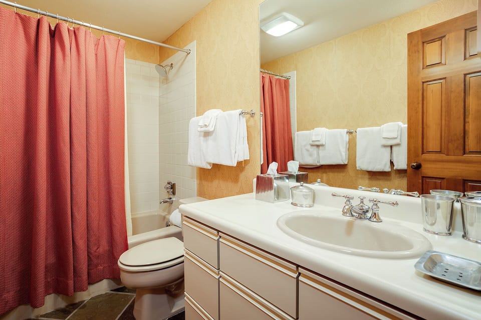 Your private bathroom offers a tub-shower combo, fresh towels, and a spacious vanity—everything you need to feel refreshed after a day of adventure.
