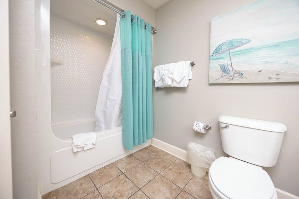 Refresh yourself in this guest bath with a soothing shower, complemented by beach-themed decor to enhance relaxation