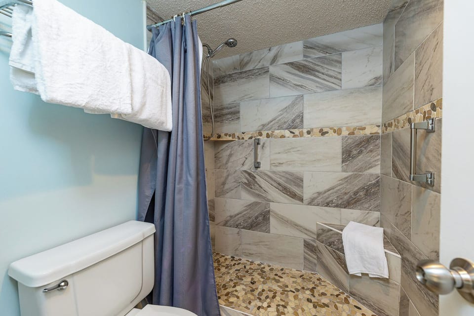 Indulge in a refreshing shower experience in the master while enjoying the stylish pebbled flooring and modern fixtures