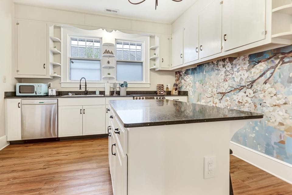 Spacious kitchen with a large island and two stools.