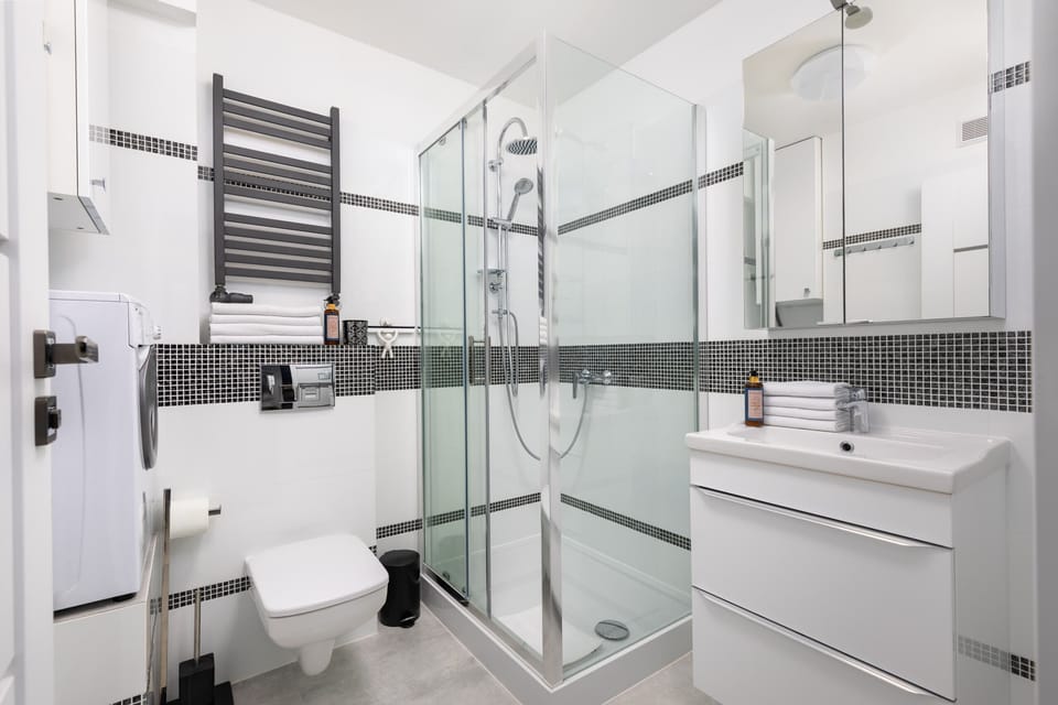 Another view of the bathroom, focusing on the walk-in shower, towel rack, and sleek design elements.

