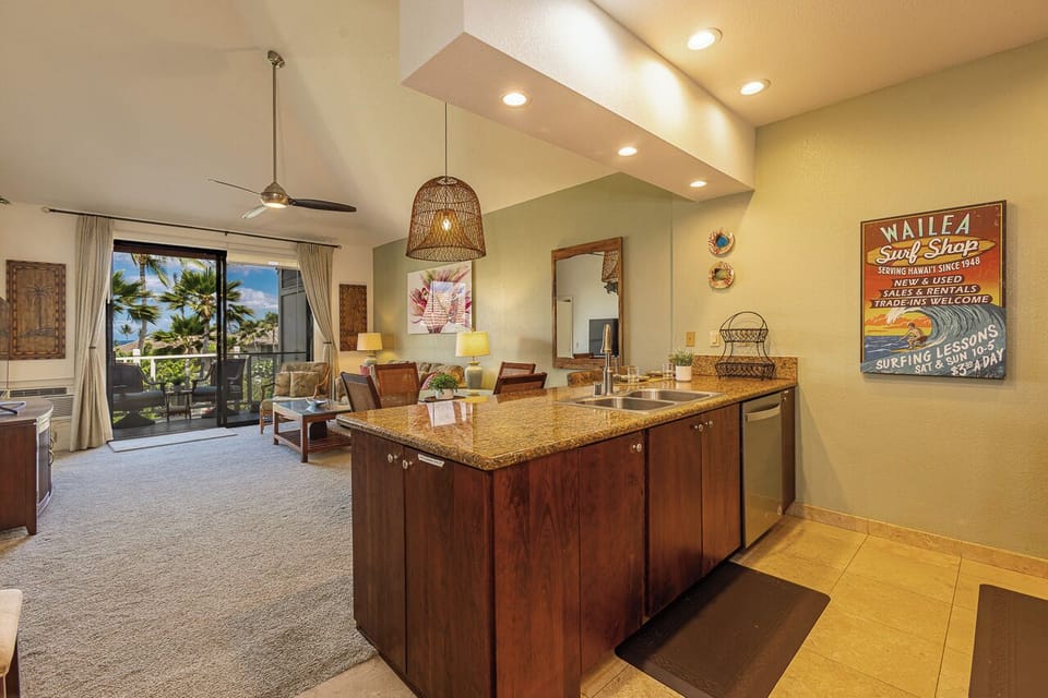 Your island kitchen flows into the living area, where tropical palms sway beyond the balcony and warm Hawaiian light fills every corner with island charm.