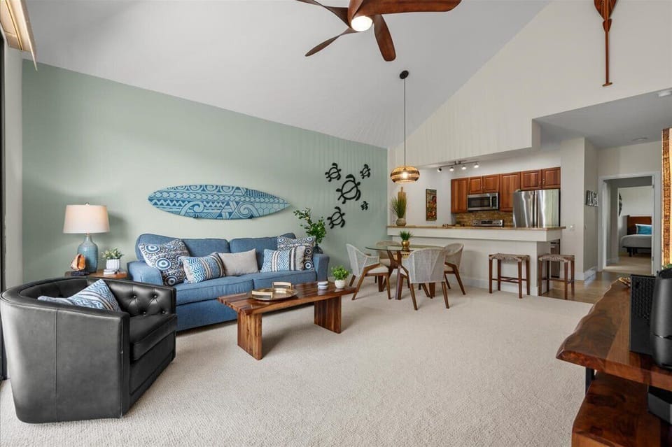 Relax in your bright, airy living space where coastal-inspired décor meets modern comfort. High ceilings, tropical ceiling fans, and surfboard art set a laid-back island vibe while the open kitchen awaits your culinary adventures.